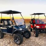 Two lifted Evolution Golf Carts at sunset.